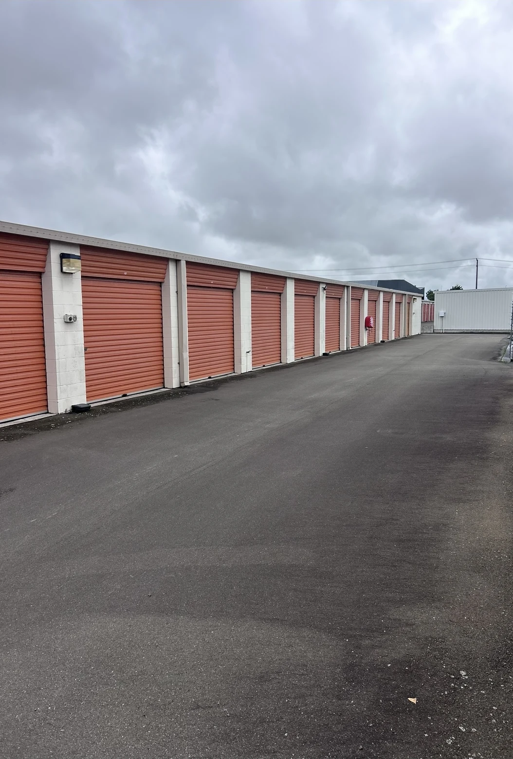 Storage units before repainting, with faded orange roller doors