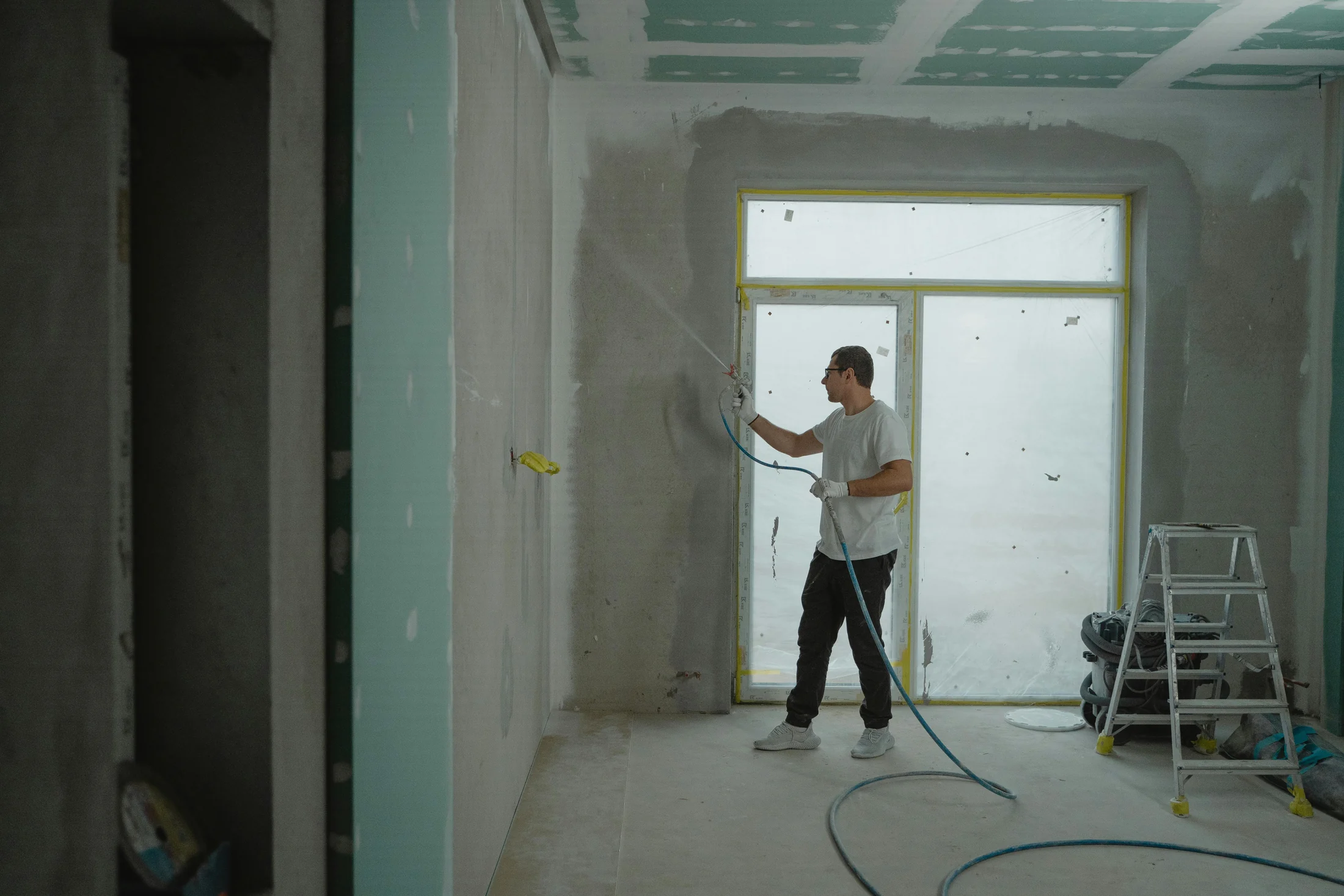 Painter spraying an interior wall